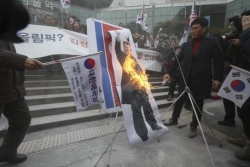 Manifestanti bruciano foto di Kim a Seul